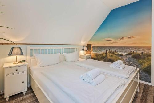 a bedroom with a bed with a painting of the beach at Loddin Ferienwohnung Inselzeit in Loddin