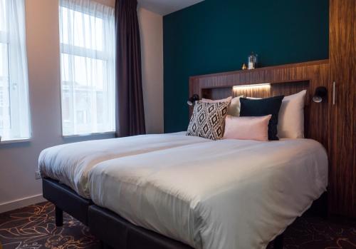 Un dormitorio con una cama grande con almohadas. en Linden Hotel, en Ámsterdam