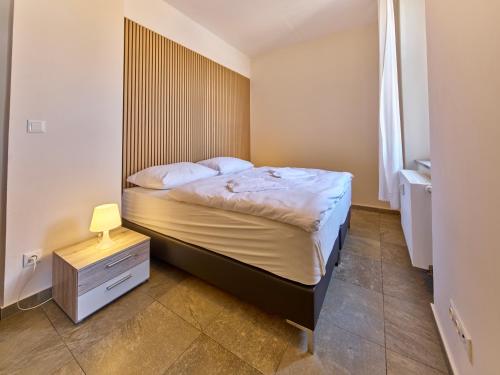 a bedroom with a bed with a wooden headboard at Teplice Apartments U Schodů in Teplice