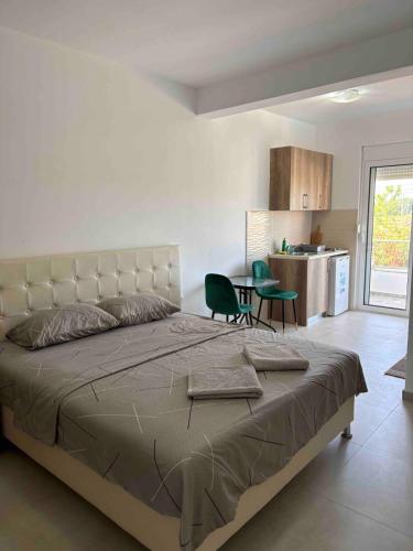 a bedroom with a large bed and a kitchen at Vesa&Veton in Donji Štoj