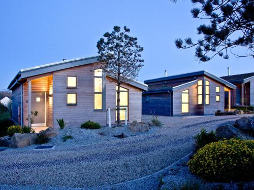 a house with lights on in a driveway at Una Argentum 62 in Carbis Bay