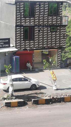a white car parked in front of a building at UK Residencia in Murree