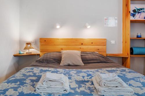 a bedroom with a bed with two towels on it at Studio La Chambrette in Blieux