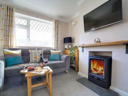 a living room with a couch and a fireplace at Sea Thrift in Port Isaac