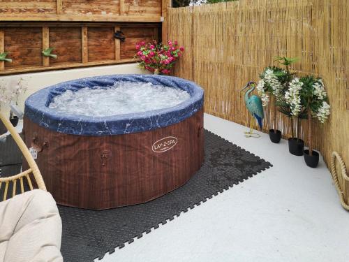 a large wooden hot tub in a yard with a bird at Alscott Cottage in Bishops Tawton