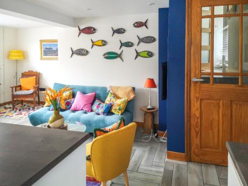 a living room with a blue couch and fish decals at Alscott Cottage in Bishops Tawton