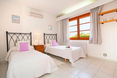 a bedroom with two beds and a window at Villa Can Tomas in Port de Pollensa