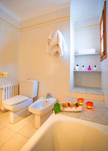 a bathroom with a toilet and a sink and a tub at Villa Can Tomas in Port de Pollensa