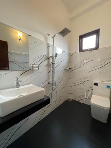 a bathroom with a sink and a toilet at Rest Inn Tourist Hotel in Gampaha