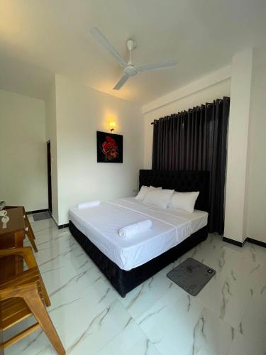 a bedroom with a large white bed with a ceiling at Rest Inn Tourist Hotel in Gampaha