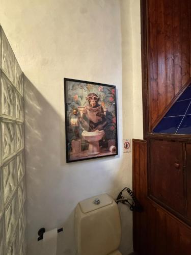 a bathroom with a painting above a toilet at Casa Tradicional Canaria - Gara in Garachico