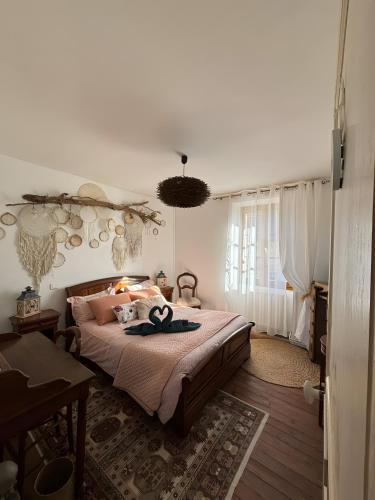 a bedroom with a bed with a hat on it at La Parenthese in Folles