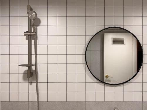 a mirror on a tiled wall with a shower at Stay PAUSE in Bucheon