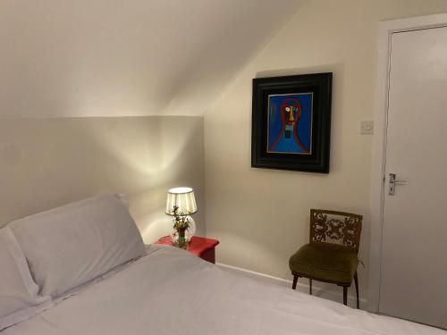 a bedroom with a bed and a chair and a lamp at Perfect for two close to Kenmare in Kenmare