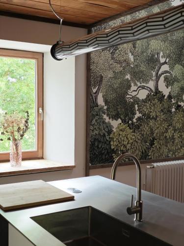 a kitchen with a sink and a painting on the wall at Domaine du Moulin Français in Champougny