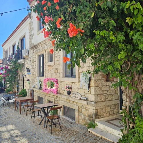 a building with tables and chairs in front of it at Afet inn in Çeşme