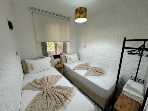 a room with two beds and a window at Afet inn in Çeşme