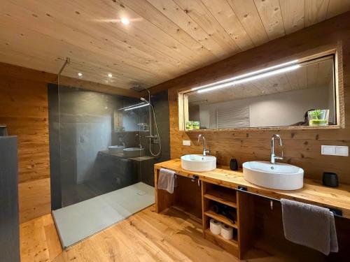 a bathroom with two sinks and a shower at Fritz Alpchalets - Haus Lechtal in Vorderhornbach