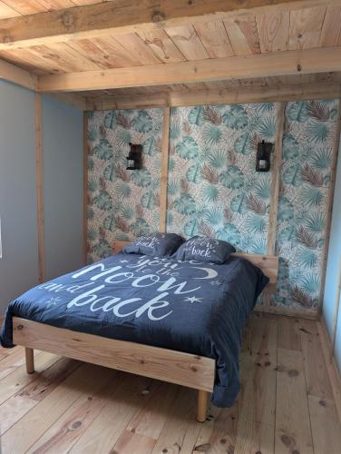 a bedroom with a bed with a blue comforter at Le relais de la mine in Champagnac
