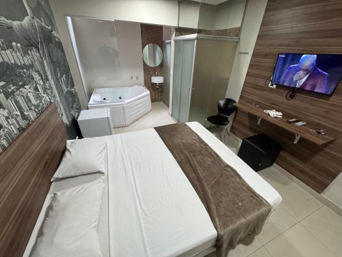 a bedroom with a bed and a flat screen tv at Add Hotéis Center Norte in São Paulo