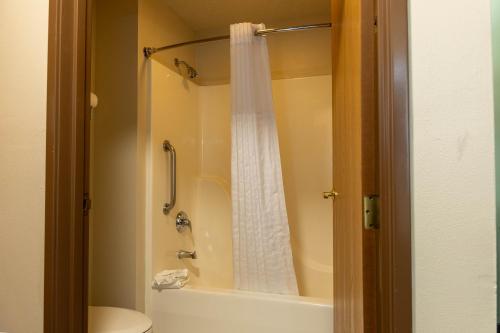 a bathroom with a shower with a white shower curtain at Wyndham Garden Madison Fitchburg in Madison
