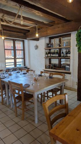 a large dining room with a large table and chairs at L'auberge des Érables in La Pesse