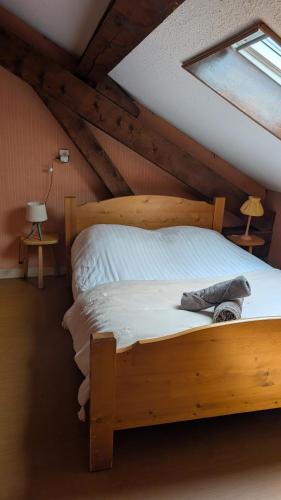 a bedroom with a wooden bed in a attic at L'auberge des Érables in La Pesse