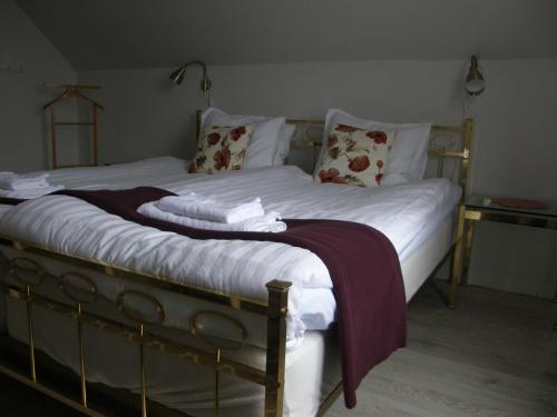 a large bed with white sheets and pillows at Monicas Rumsuthyrning in Borgholm