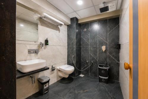 a bathroom with a toilet and a sink and a shower at hotel green rio in Ahmedabad