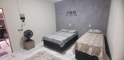 a bedroom with two beds and a fan at Loft urbano in Martins