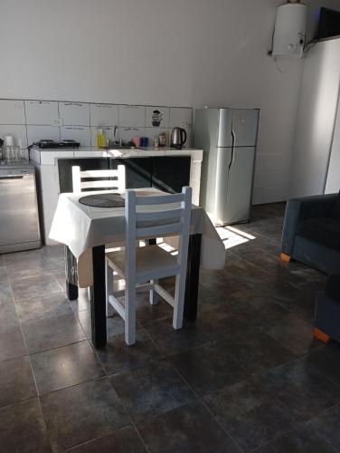 a kitchen with a table and chairs and a kitchen with a refrigerator at Tu rincón, lugar de descanso in Chascomús