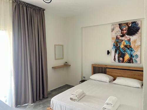 a bedroom with a bed and a painting on the wall at Rafael & Sofia Luxury Suites in Ammoudia