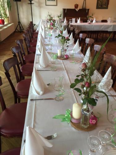 a long table with white tables with flowers and candles at Bergschlößchen in Jüterbog