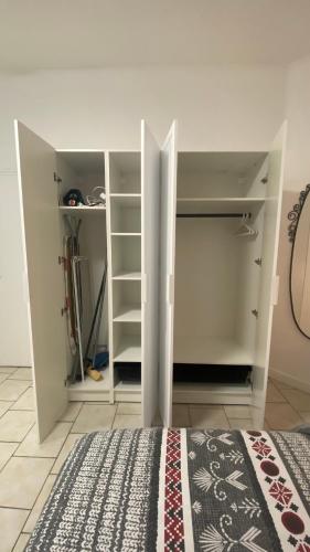 a room with a closet with shelves and a bed at Gite Escale en Ville in Louviers