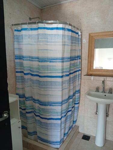 a bathroom with a shower curtain and a sink at Tu rincón, lugar de descanso in Chascomús