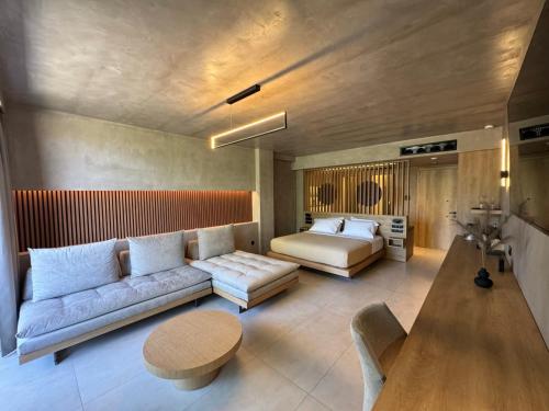a living room with a couch and a bed at Elegance Suites in Pyrgos