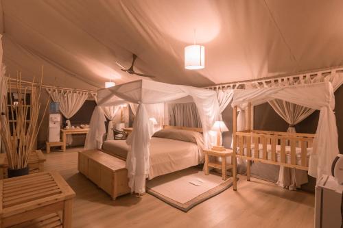 a bedroom with a canopy bed in a tent at Mara Maisha Camp in Talek
