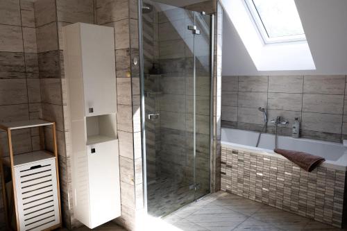 a bathroom with a shower and a bath tub with a window at Ubytování Dědinka in Mladkov