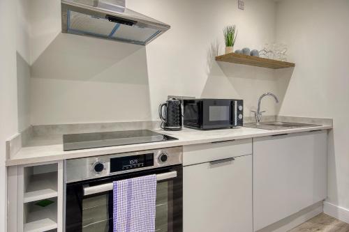 a kitchen with a sink and a stove top oven at The Studio Castle Lane in Bournemouth
