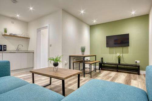 a living room with two blue couches and a table at The Studio Castle Lane in Bournemouth