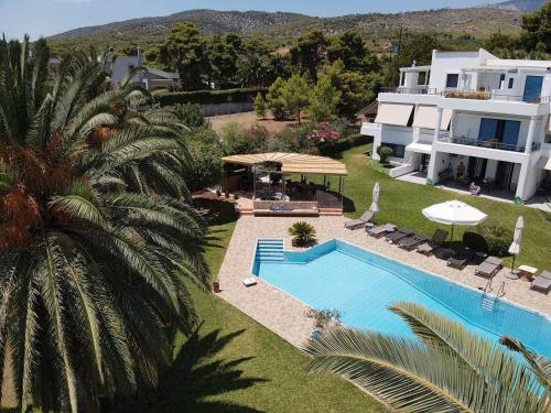 an aerial view of a house and a swimming pool at Kinetious Nisous Stylish Apt, Pool, near the Beach in Kineta