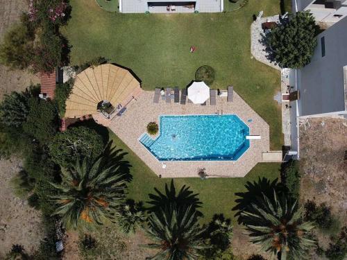 an overhead view of a swimming pool with an umbrella at Kinetious Nisous Stylish Apt, Pool, near the Beach in Kineta