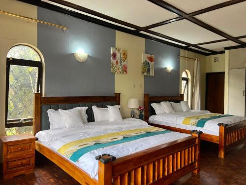 a bedroom with two beds and a window at Ilemi Gardens in Nairobi