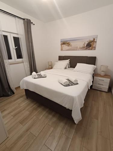 a bedroom with two beds and a wooden floor at Vila Nikola in Pučišća