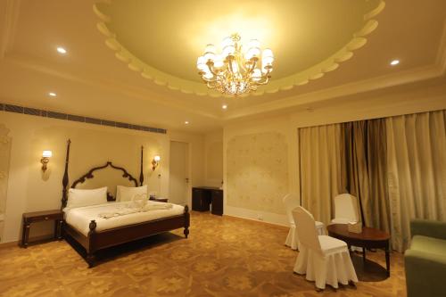 a bedroom with a bed and a chandelier at Rajwada Hotel and Resort in Bareilly