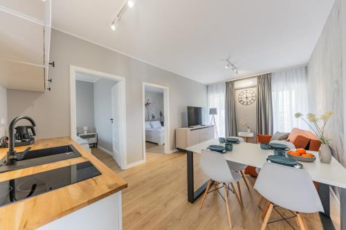 a kitchen and living room with a table and chairs at Apartamenty i pokoje deluxe PÓŁNOCNA PRZYSTAŃ in Przewłoka