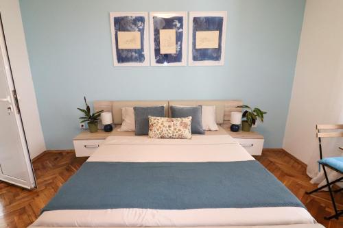 a bedroom with a large bed with blue walls at Bonaca Room in Donja Lastva