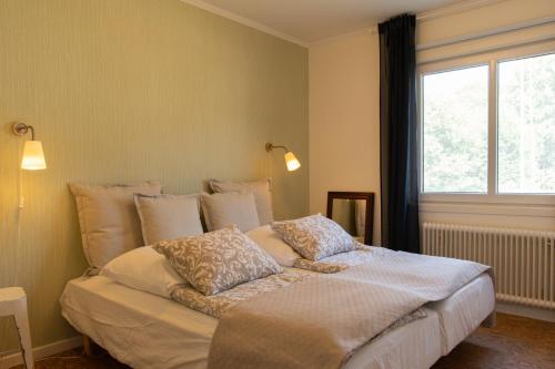 a bedroom with a bed with pillows and a window at Cozy Smalandcottage Alsterfors 23 - towels, bed linen and toiletries provided - in Alsterfors