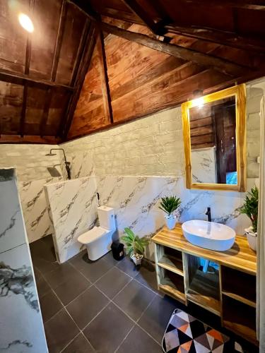 a bathroom with two toilets and a sink at Aulia Bungalows Tetebatu in Tetebatu