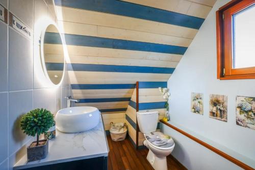 a bathroom with a white toilet and blue stripes at Chambres à l'écrin de bois in Guerlédan
